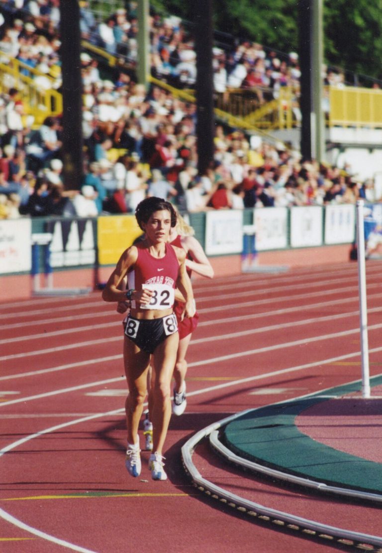 Leigh Daniel Cordes racing along a red track in a Texas Tech uniform with spectators in the stands