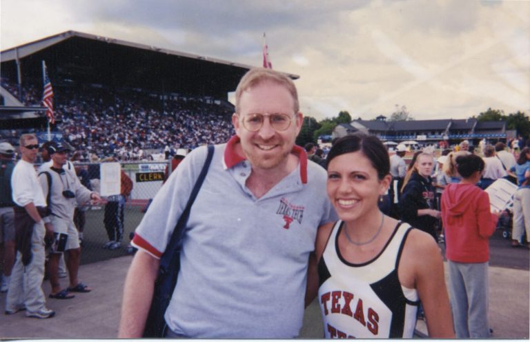 Man in a gray Texas Tech polo posing with a runner in a Texas Tech singlet at a track meet, Leigh Daniel Cordes collection