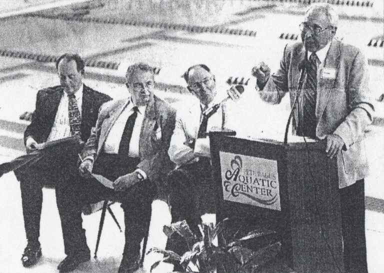 Pete Ragus speaking at the podium during the dedication of the Pete Ragus Aquatic Center, from a newspaper photo