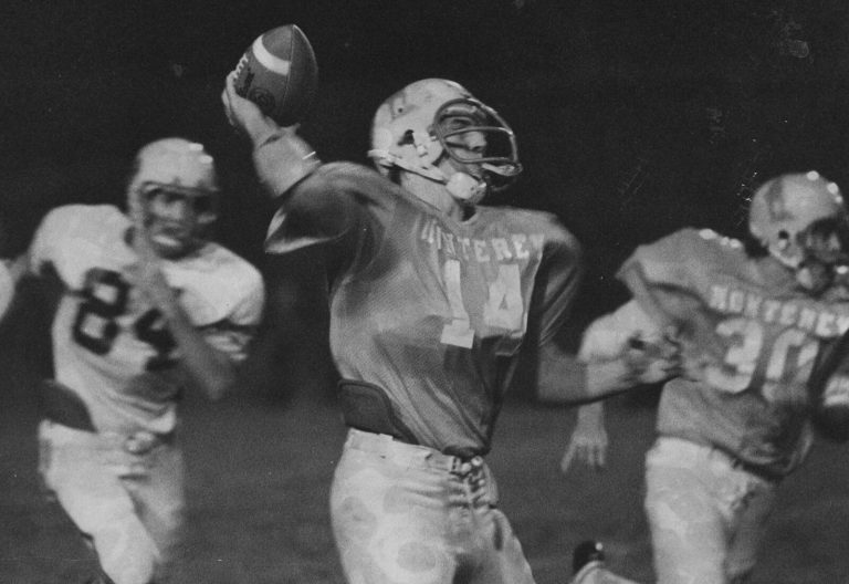 Ron Reeves in a Monterey number 14 jersey cocking the ball to pass as a number 84 opponent closes in