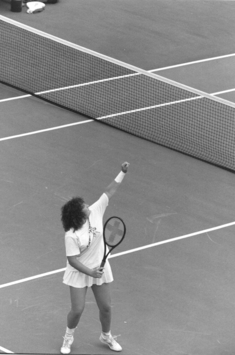 Tanya Hamilton Bryant and Lara Mahaney: Tanya serving on a tennis court, black and white