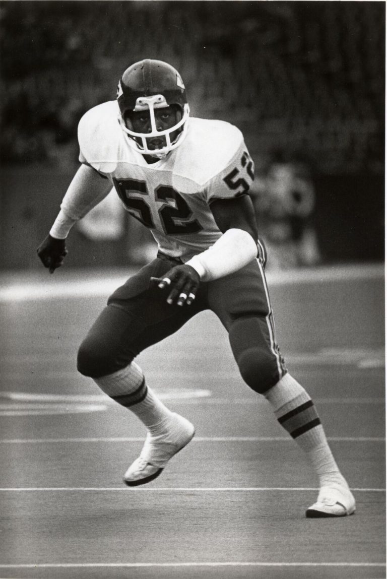 Thomas Howard in a No. 52 jersey in a ready stance in a black-and-white game photo