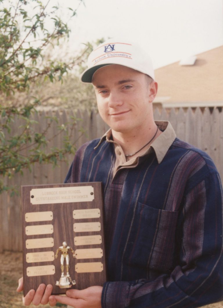 Thomas Klement in an Auburn University cap holding a Lubbock High School Outstanding Male Swimmer plaque