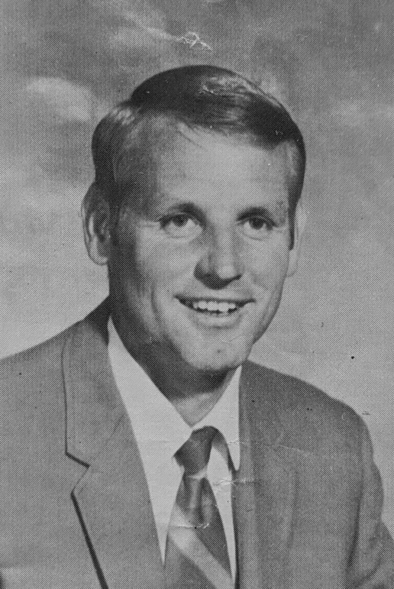 1970 State Champion Track Team coach Hollis Gainey in a suit and tie, black-and-white portrait