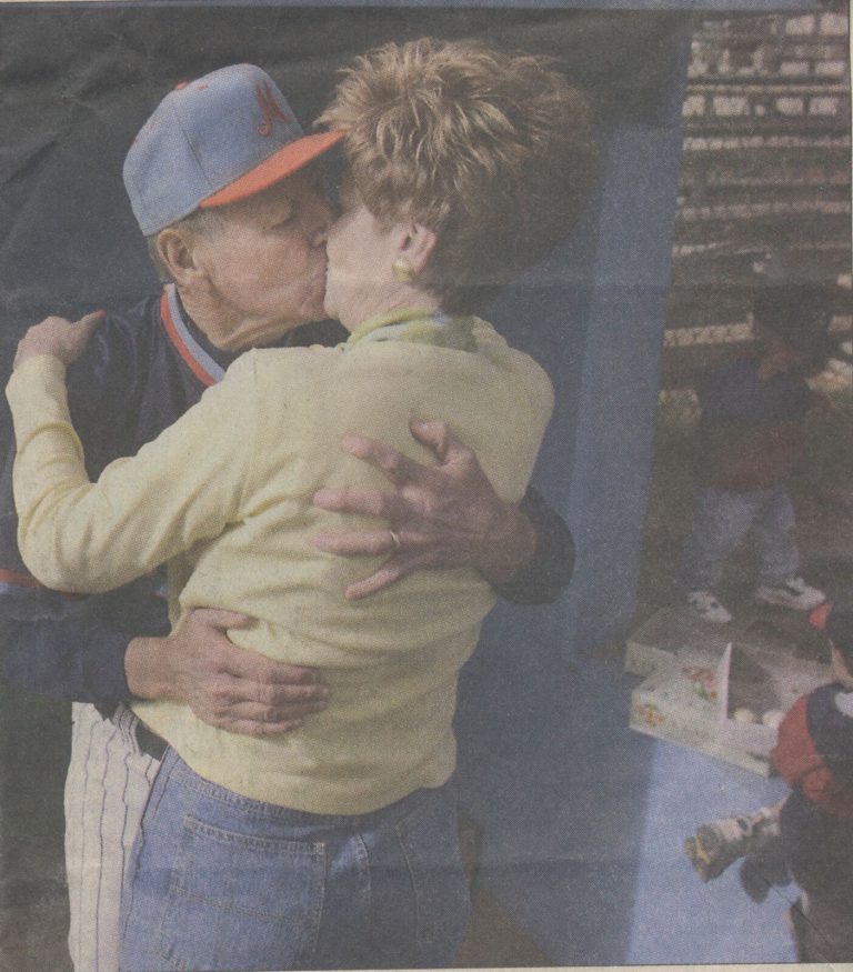1981 State Champion Baseball Team coach in a ballcap hugging a woman after the title win, from a newspaper clipping