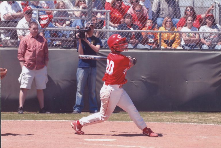 Amanda Parsons swinging at the plate in a red Coronado number 20 jersey