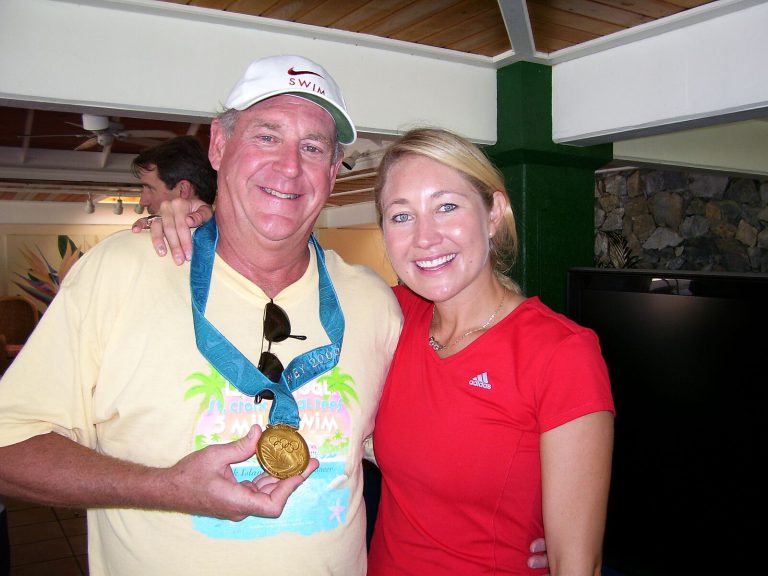 Ron Holihan wearing swimmer Misty Hyman's Olympic gold medal as the two pose together