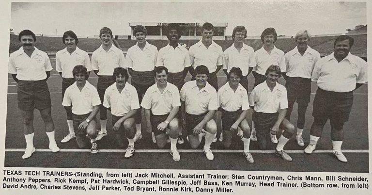 Anthony Peppers, fifth from left standing, with the Texas Tech trainers in a team photo with a printed names caption