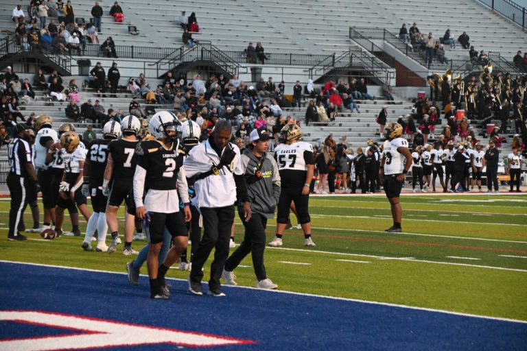 Anthony Peppers walks the sideline with Lubbock High football players during a game.