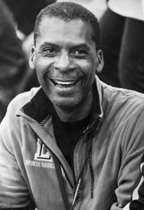 Anthony "Coach Pep" Peppers smiles in his Lubbock High Sports Medicine jacket at a game.