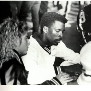 Anthony Peppers tends to a helmeted Lubbock High football player on the sideline in a 1980s yearbook photo.