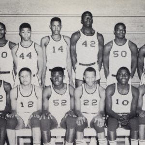 The Dunbar High School Panthers basketball team poses in uniform with coaches in an early 1960s team photo.
