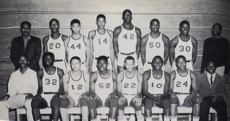 The Dunbar High School Panthers basketball team poses in uniform with coaches in an early 1960s team photo.