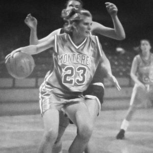 Kim Sumrall in her Monterey number 23 uniform driving with the basketball during a 1990s game