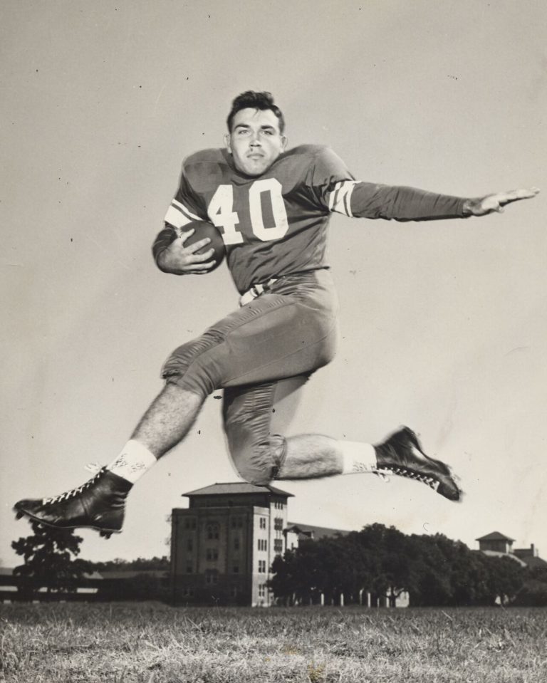 Mac Taylor leaping with the football in a number 40 jersey on a practice field