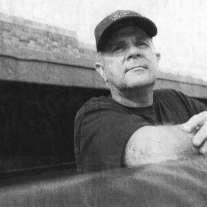 Robert "Prof" Ramos in a ball cap looks out from the Estacado dugout in a newspaper photo marking his retirement.