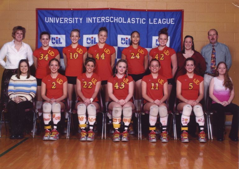 The Coronado Lady Mustangs volleyball team and coaches pose in front of a UIL banner in the mid-2000s.