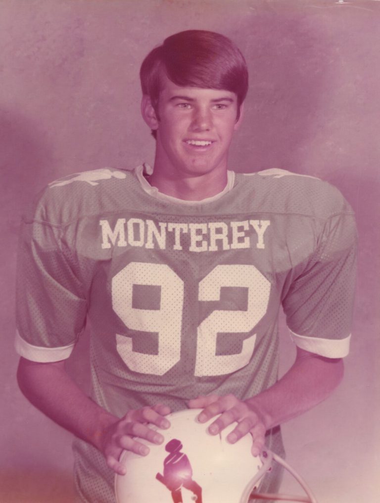Tim Leslie in a Monterey number 92 football jersey holding a helmet, color portrait